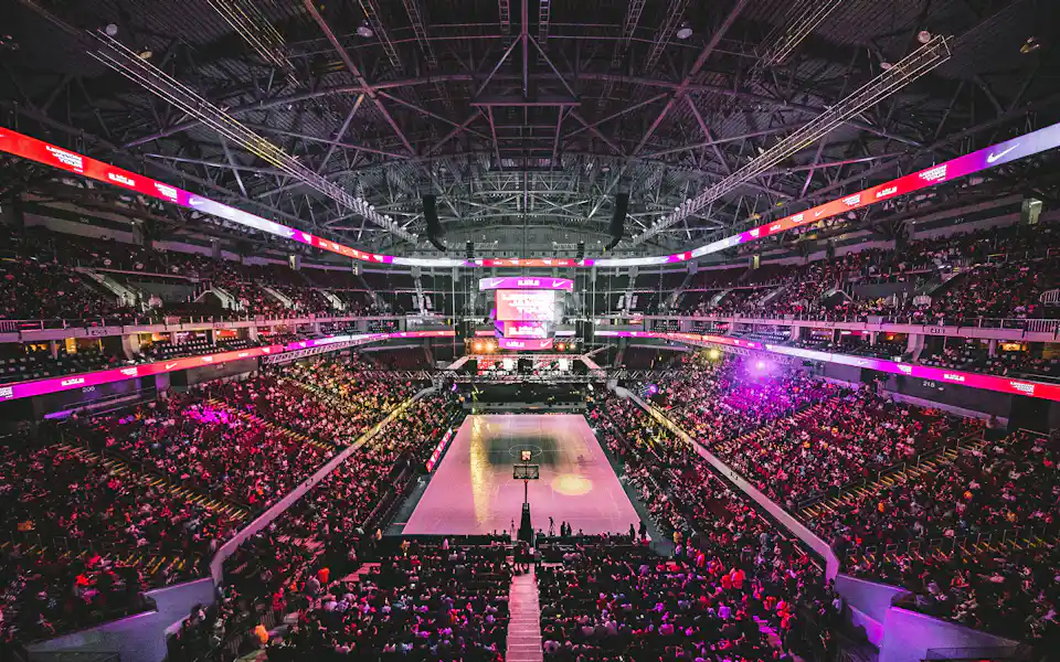 Packed indoor arena crowd watching a live basketball game