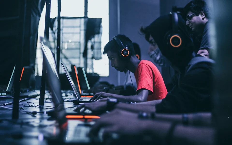 Young gamers wearing headsets playing together at gaming stations
